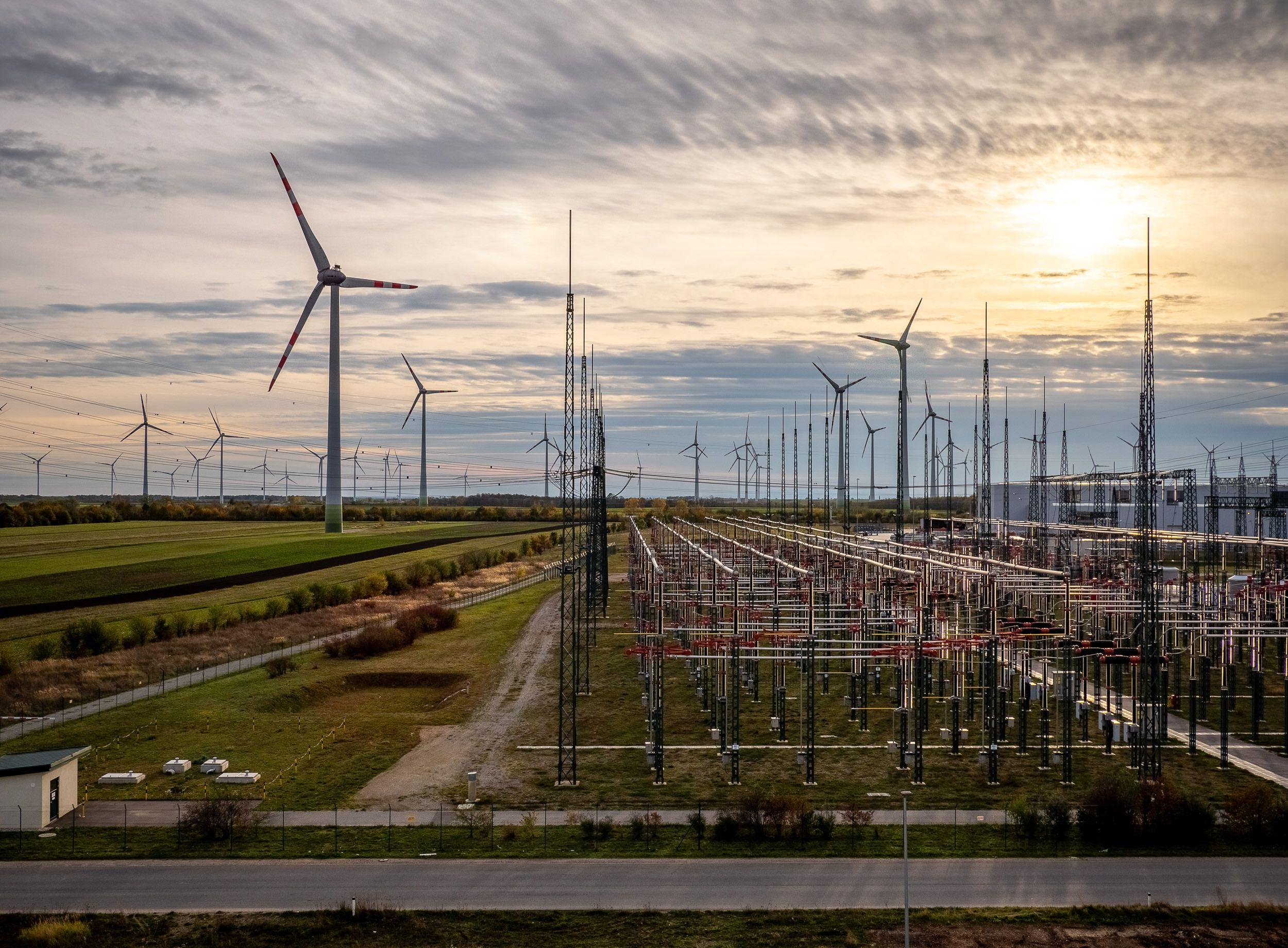 Umspannwerk von Netz Burgenland mit zahlreichen Windrädern bei Sonnenuntergang.