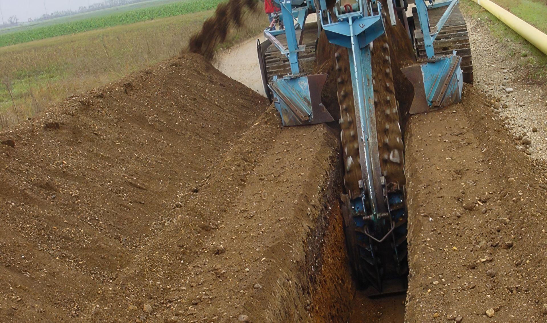 Baumaschine mit Kabelpflug beim Ausheben eines Grabens für die Verlegung von Stromkabeln.